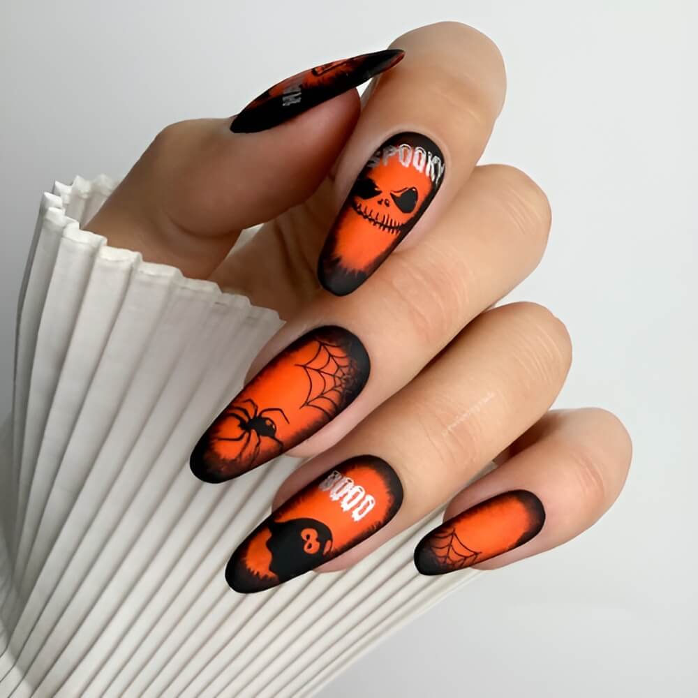 Bright orange Halloween nails with skeleton face and spider details