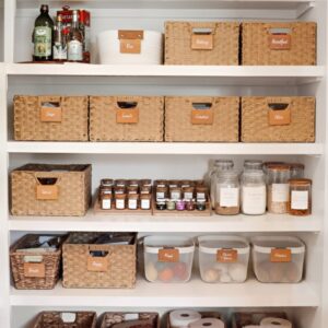 Woven and plastic baskets organizing pantry items into categories. Small pantry organization