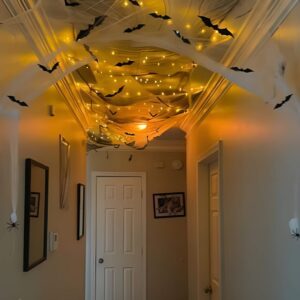 Cobweb-covered staircase and shelves with fake spiders for creepy Halloween atmosphere