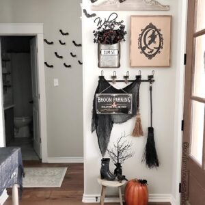 Entryway decorated with rustic witch brooms and signage for whimsical Halloween welcome. Halloween Decor