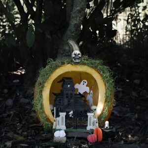 Carved pumpkin with mini haunted scene diorama and LED lights for creative Halloween display. Halloween Decor