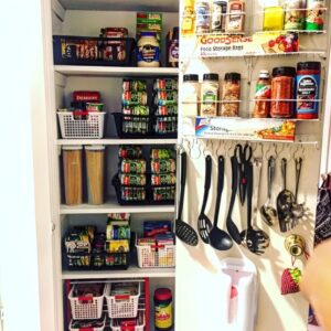 Hooks installed inside pantry door holding measuring cups and oven mitts. Small pantry organization