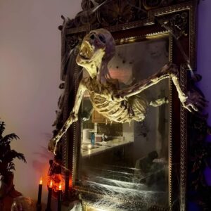 Skeleton figure crawling from a mirror with cobwebs and spooky lighting for Halloween setup. Halloween Decor