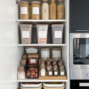 Tiered shelf organizer used for canned goods in a narrow pantry. Small pantry organization. Small pantry organization