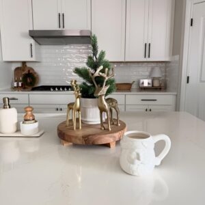 Small Christmas figurines decorating kitchen shelves for a cute and festive holiday touch.
