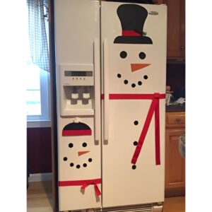 Festive refrigerator decorated with Christmas magnets and a holiday wreath in the kitchen.