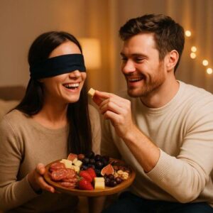 Couple playing a blindfolded taste test game with snacks for a funny and romantic at-home date night.