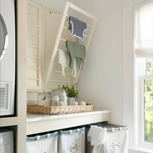 Foldable wall-mounted drying rack in a laundry room used for air drying delicate clothes. Laundry room organization