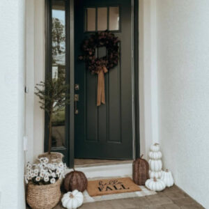 Seasonal fall doormat layered over a plaid outdoor rug at the front entrance.