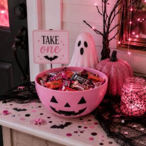 Pink Halloween candy station with a large bowl filled with Halloween treats