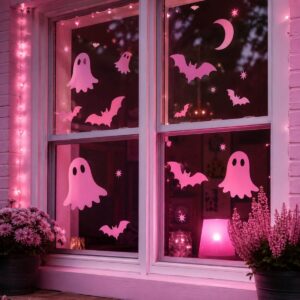 Window decorated with cute pink Halloween bats and spooky decorations